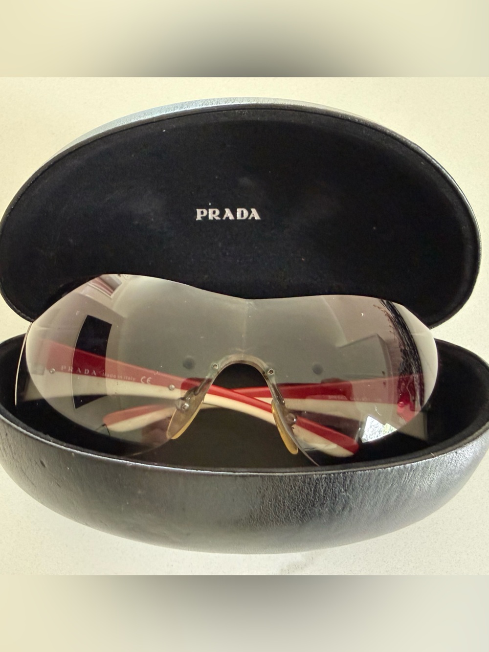 Prada Rimless Shield Sunglasses in Clear Gradient with Red/White stripe